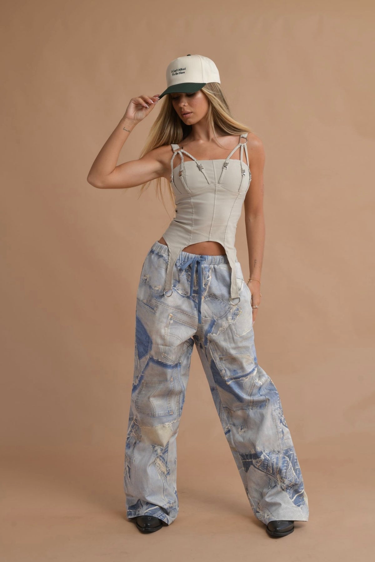 Model wearing blue denim cargo pants with a relaxed fit and drawstring waist, styled with a cropped top.