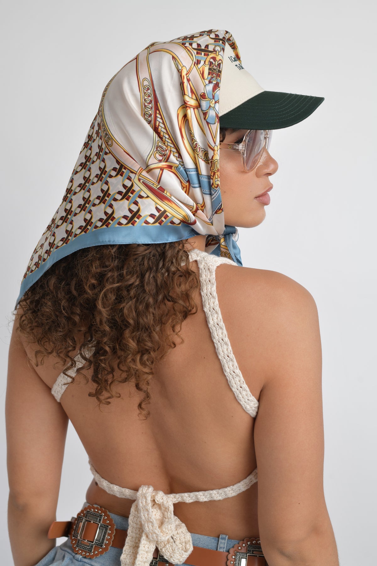 Versatile fashion scarf with a bold print, styled with sunglasses and a crochet top.