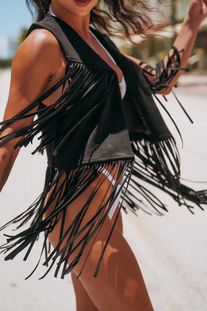 Black fringe vest with open front and sleeveless design, perfect for layering over swimsuits

