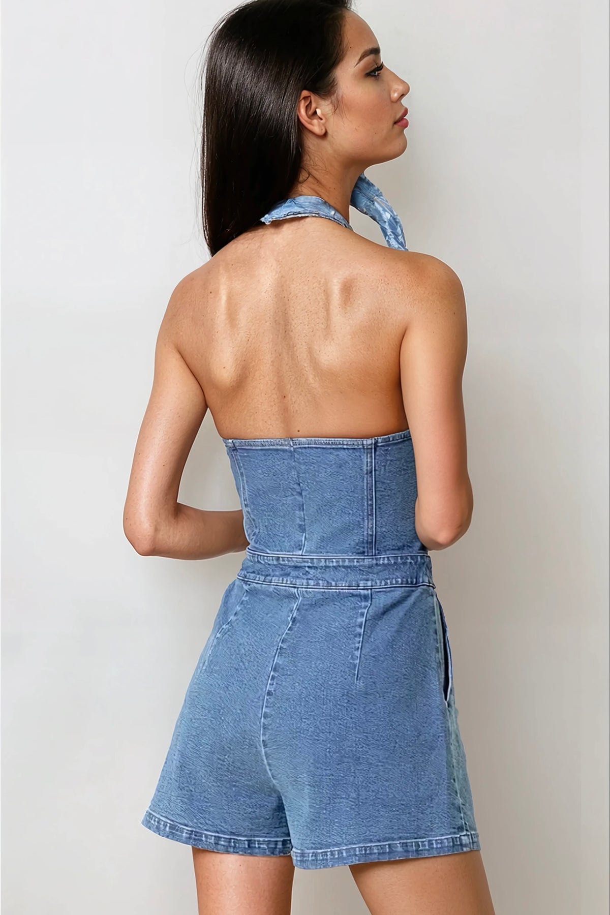 Casual denim romper featuring side pockets and medium wash stretchy fabric
