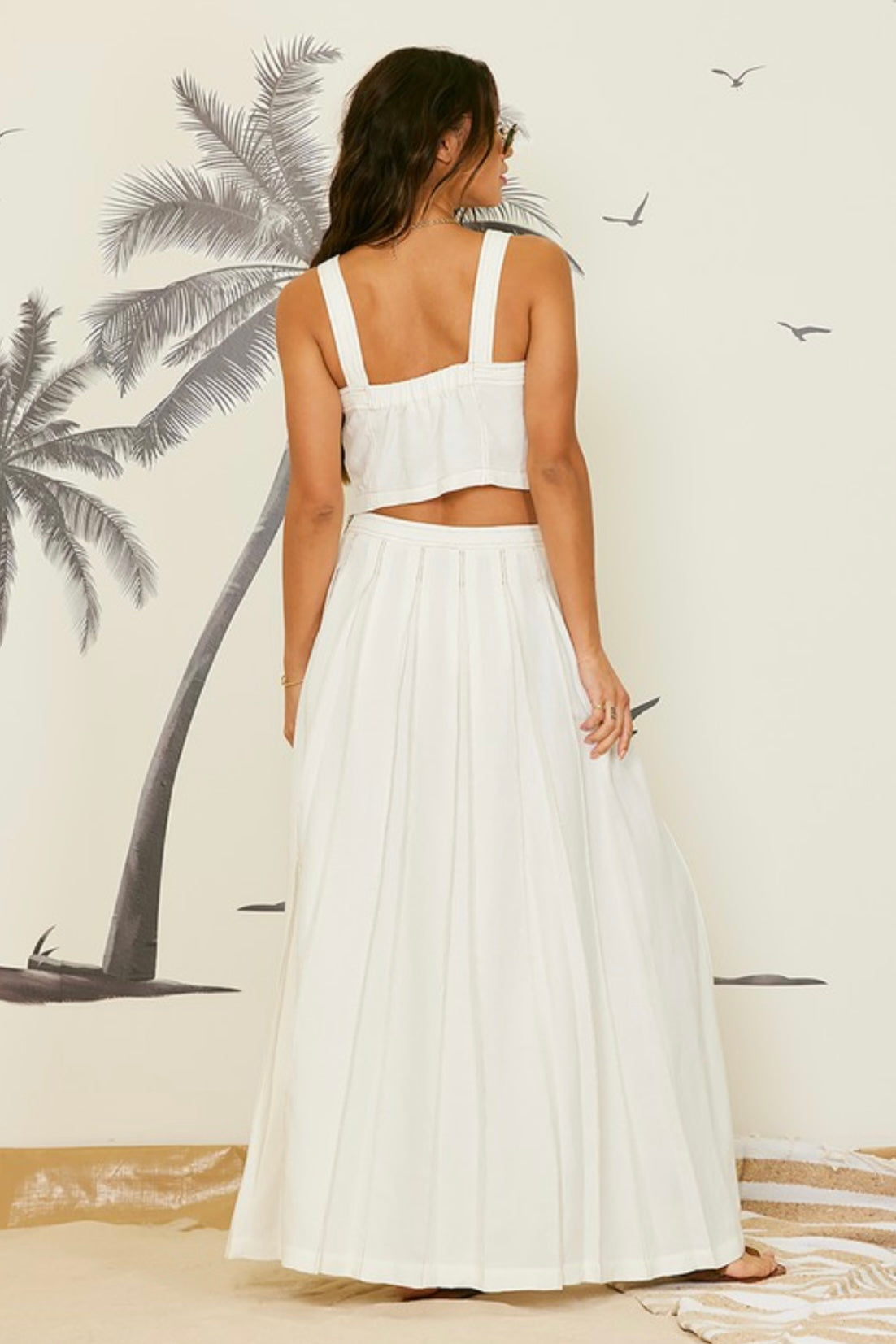 Cream linen two-piece set styled for a beach day with cropped top and maxi skirt
