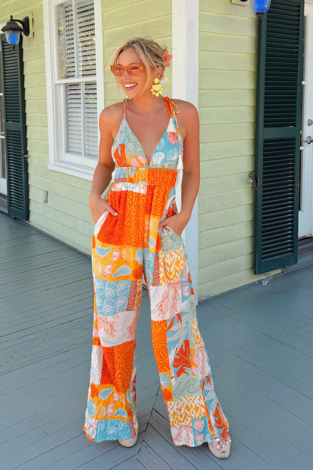 V-neck jumpsuit with shoulder ties and tassel detail for a playful, boho vibe
